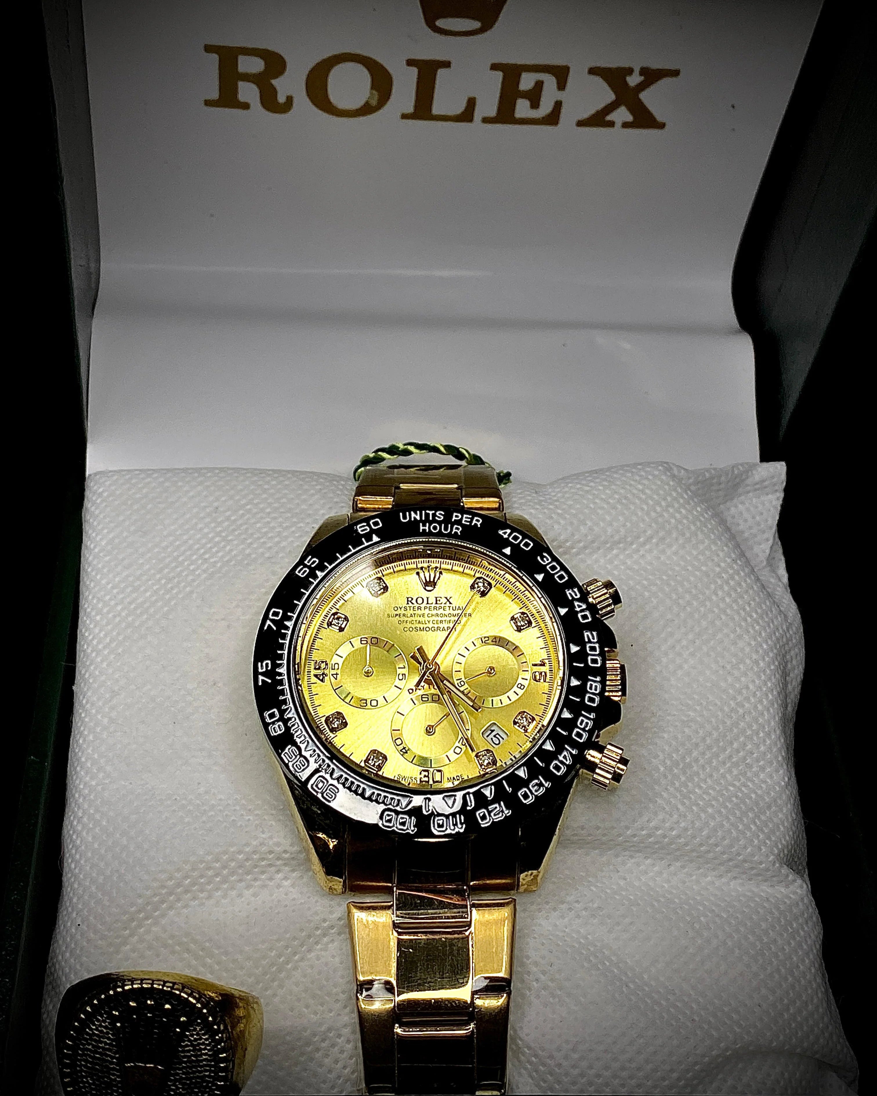 Gold and black Rolex watch on a white background with Rolex branding.